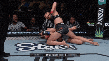 two women are wrestling in a cage with a sign that says tequila