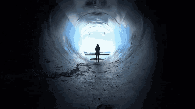 a person is standing in the middle of a tunnel