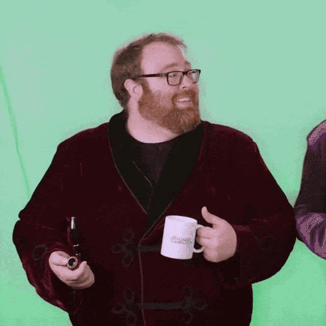 a man with a beard is holding a pipe and a mug that says ' sherlock holmes ' on it
