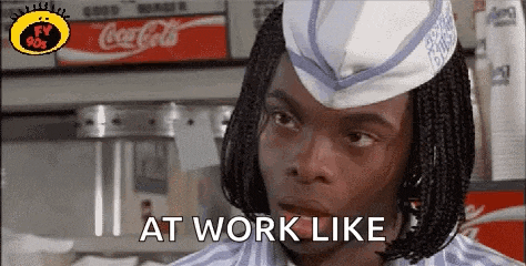 a man with braids is wearing a hat and saying `` at work like '' in a fast food restaurant .