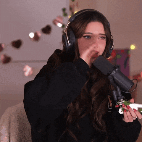 a woman wearing headphones is singing into a microphone while holding a christmas tree