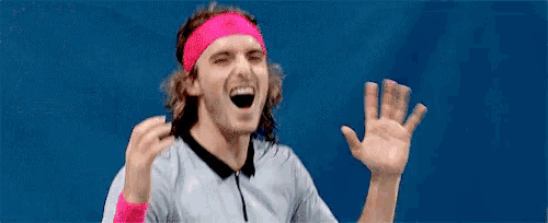 a tennis player wearing a pink headband and wristbands is laughing and waving his hand .