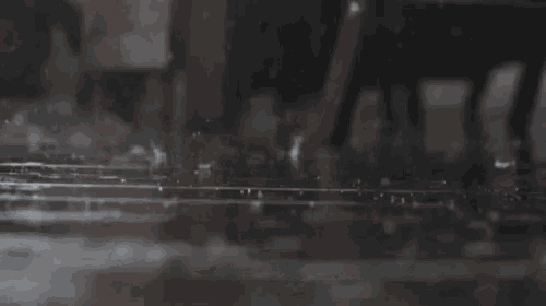 a close up of a person walking in the rain on a rainy day .