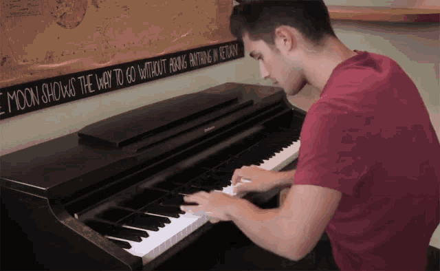 a man playing a piano in front of a sign that says the moon shows