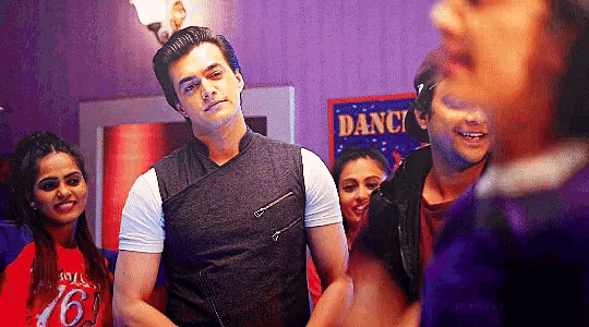 a group of people are standing in a room with a sign that says dance on it .