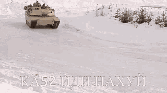 a tank is driving through a snowy field with ka52 written on the bottom right