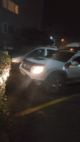 a white car with a roof box on top of it has a license plate that starts with k on it