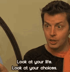 a man is looking at himself in the mirror and saying look at your life look at your choices .