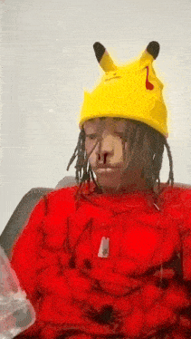 a person wearing a yellow pikachu hat and a red sweater .