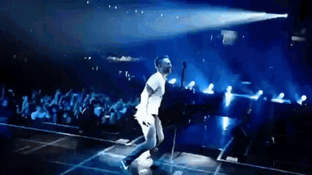 a man is singing into a microphone on a stage