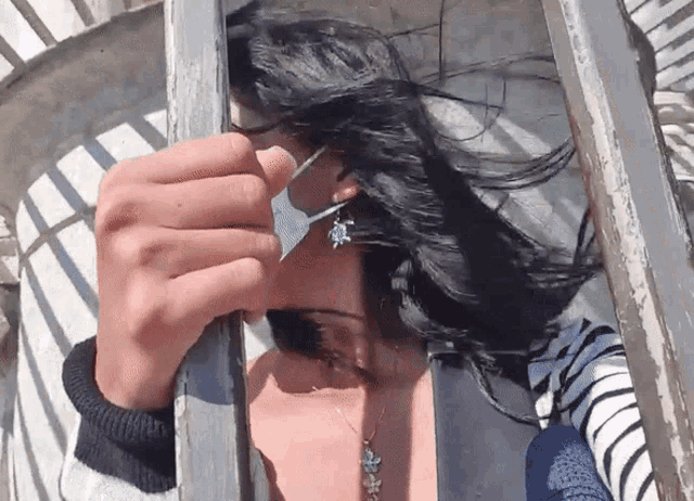 a woman wearing earrings with a turtle on them is looking through a window