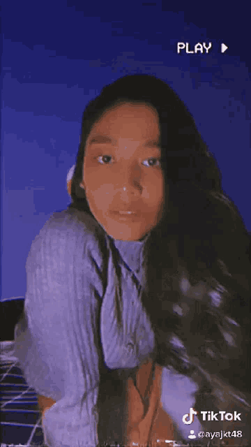 a tiktok video of a young woman with long hair