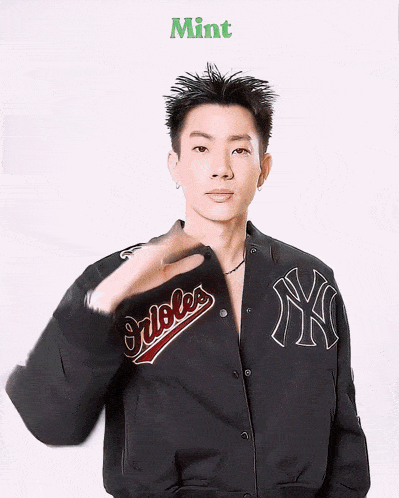 a man wearing a black jacket with orioles on the back