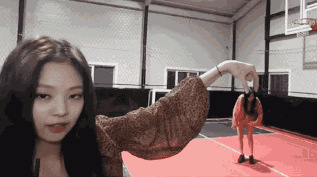 a woman is holding another woman 's hand in a basketball court