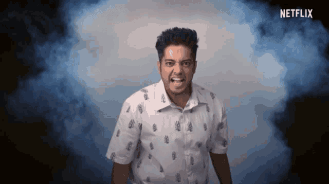 a man in a white shirt with pineapples on it stands in front of a netflix logo
