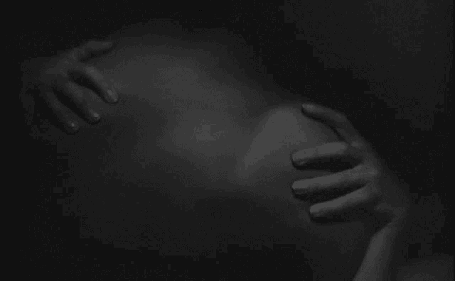 a person holding another person 's hand in a black and white photo .
