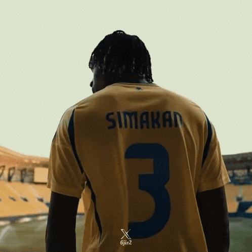 a soccer player wearing a yellow jersey with the number 3 on it