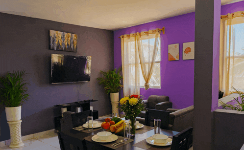 a living room with purple walls and a flat screen television