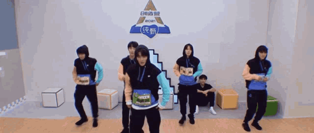 a group of young men are dancing in a room with a sign that says ecm on it