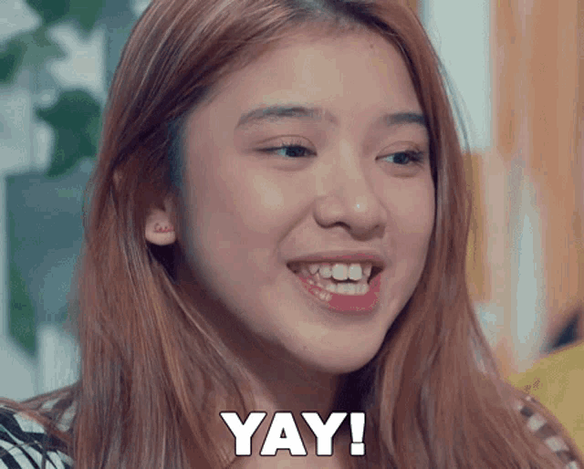 a young woman is smiling with the word yay written on her face