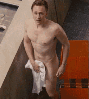 a naked man is standing in a bathroom holding a towel over his penis .