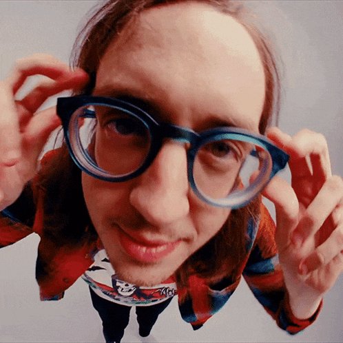 a man wearing glasses and a plaid shirt with a picture of a woman on it