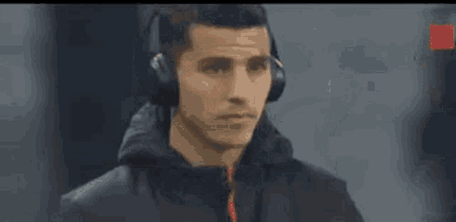 a man wearing headphones is standing in front of a camera .