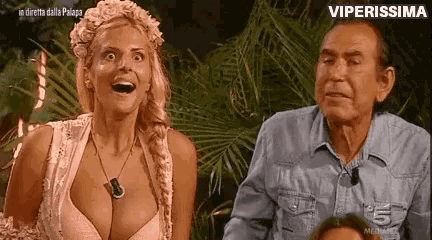 a man and a woman are sitting next to each other in a jungle .