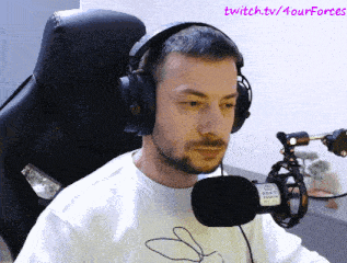 a man wearing headphones sits in front of a microphone with twitch.tv/fourforces written in the corner