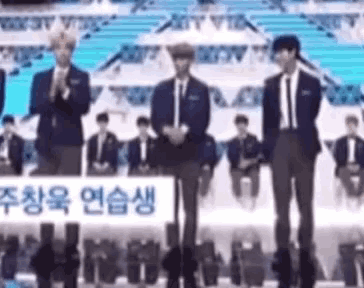 a group of men in suits and ties are standing on a stage