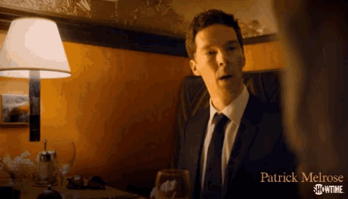 a patrick melrose showtime ad features a man in a suit and tie holding a glass