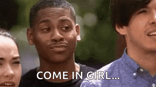 a man is standing in front of a group of people and saying come in girl .