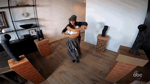 a man and woman are dancing in a room with brick pillars and abc written on the bottom right