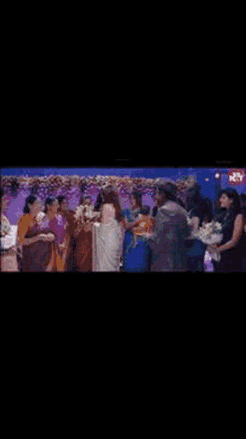 a man is giving a woman a bouquet of flowers at a birthday party
