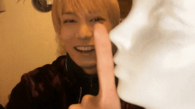 a man holds his finger to his mouth in front of a mannequin face