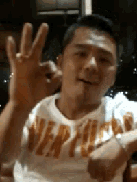a man wearing a shirt that says vertigo is waving his hand
