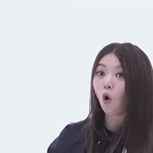 a young woman is making a surprised face with her mouth open .