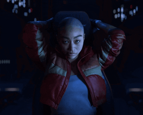 a woman with a shaved head and a red jacket