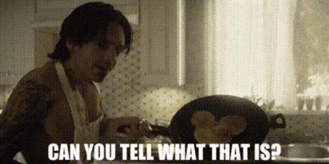 a shirtless man in an apron is cooking pancakes and asking " can you tell what that is " .