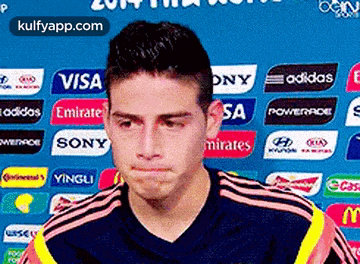 a soccer player is making a funny face in front of a sign that says visa