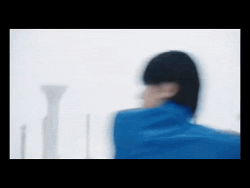 a blurry picture of a person wearing a blue jacket .