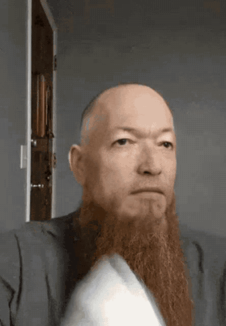 a man with a long red beard is sitting on a couch