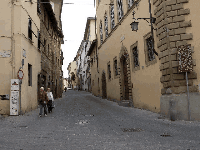 people walking down a narrow street with a sign that says " ristorante "