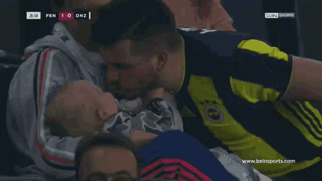a soccer player kisses another player on the cheek during a game sponsored by bein sports