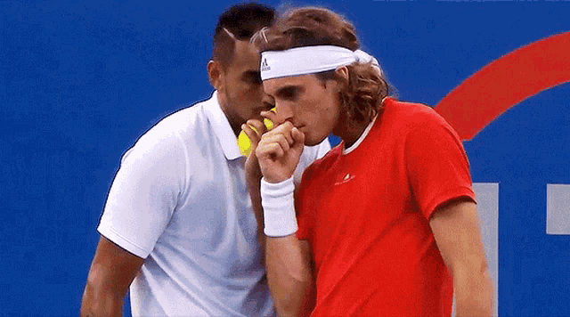 a man wearing a headband that says adidas on it talks to another man