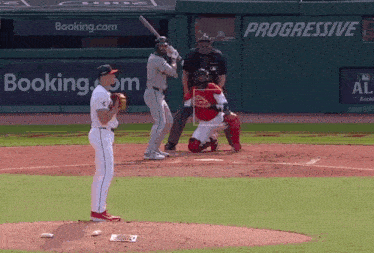 a baseball game is being played in front of a booking.com ad