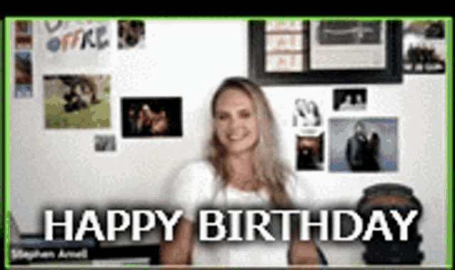 a woman is sitting in front of a wall with pictures and the words happy birthday