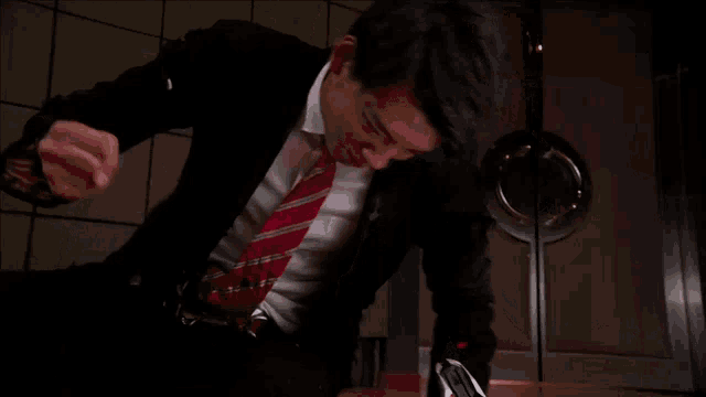 a man in a suit and tie screams with his mouth open