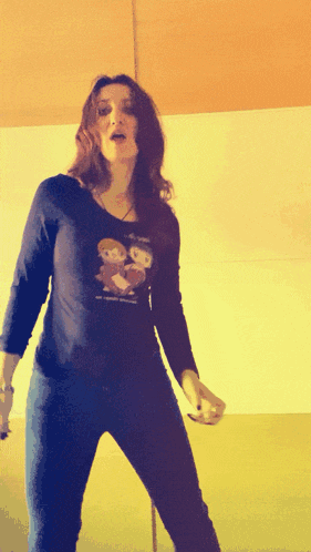a woman wearing a shirt that says ' i love you ' on it is dancing