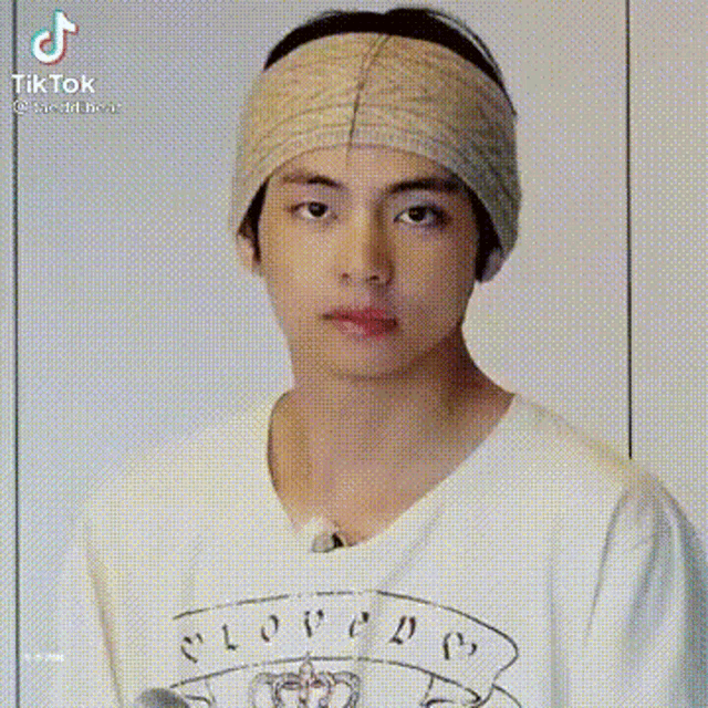 a young man wearing a headband and a white shirt .